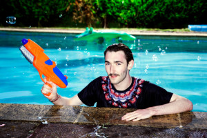 Portaint of male teenager in Pool with water gun